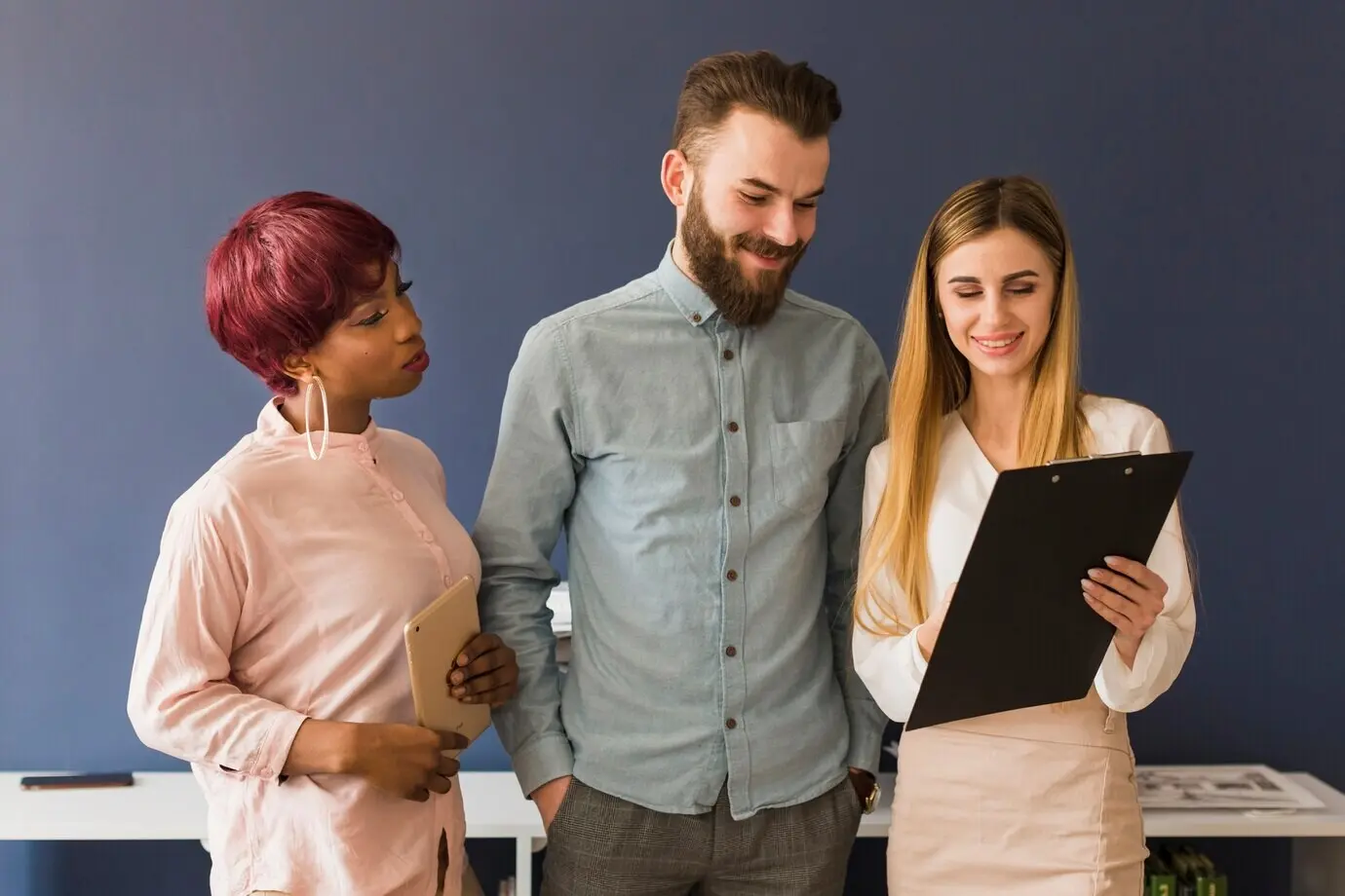 Menschen schauen auf ein Klemmbrett.